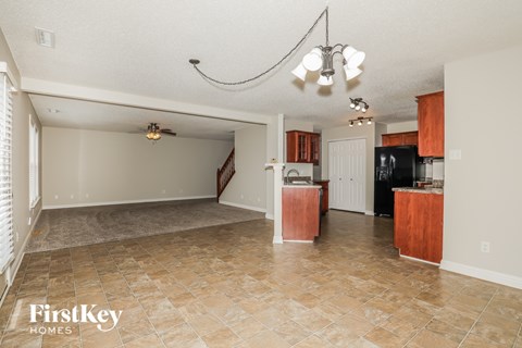 A kitchen area with a tile floor and a dining area with a table and chairs.