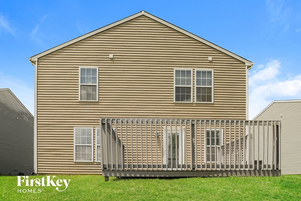A house with a wooden exterior and a deck in front.