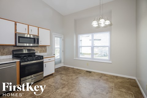 a kitchen with a stove top oven and a window