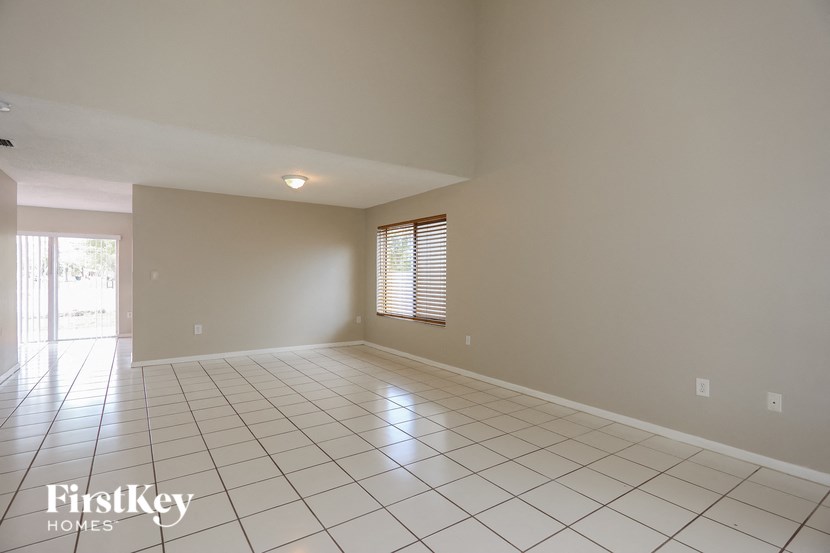an empty living room with a tiled floor