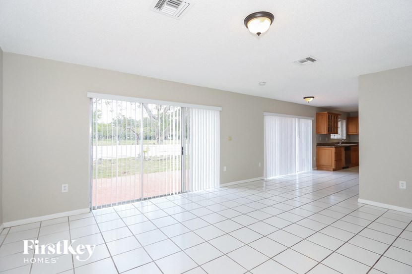 an empty living room with sliding glass doors to a patio