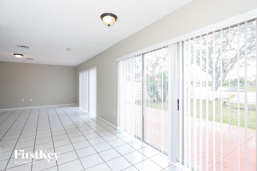 an empty living room with sliding glass doors to a patio