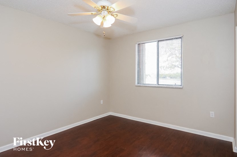 a bedroom with a ceiling fan and a window