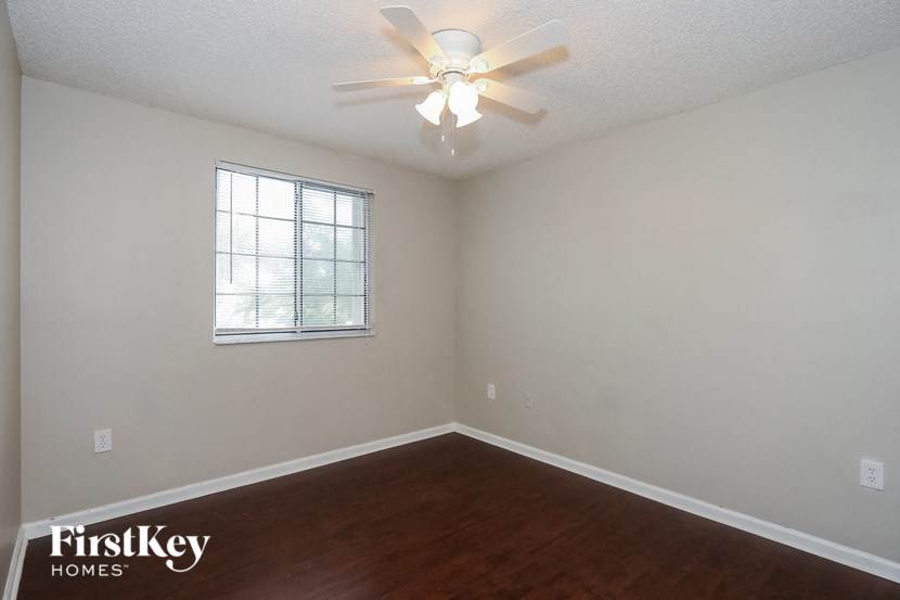 a bedroom with a ceiling fan and a window