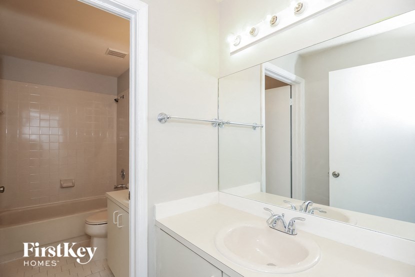 a white bathroom with a sink and a mirror
