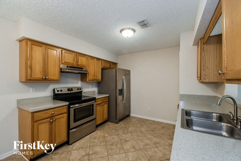 A kitchen with wooden cabinets and a stainless steel refrigerator.