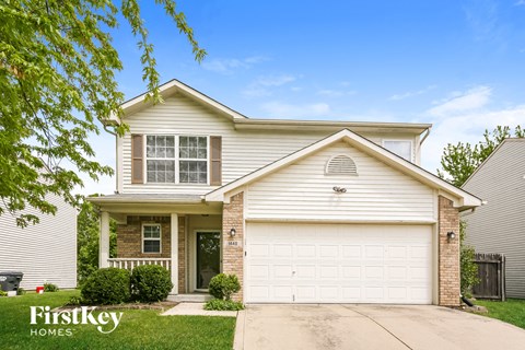 a white and brick house with a white garage door