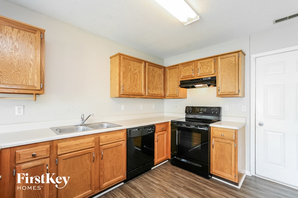 a kitchen with wooden cabinets and black appliances