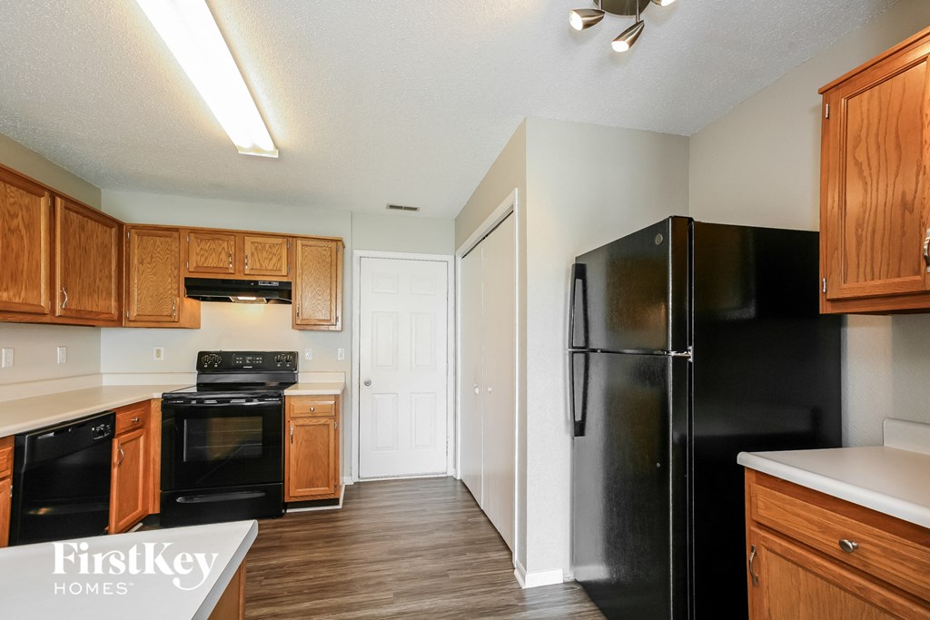 a kitchen with black appliances and wooden cabinets