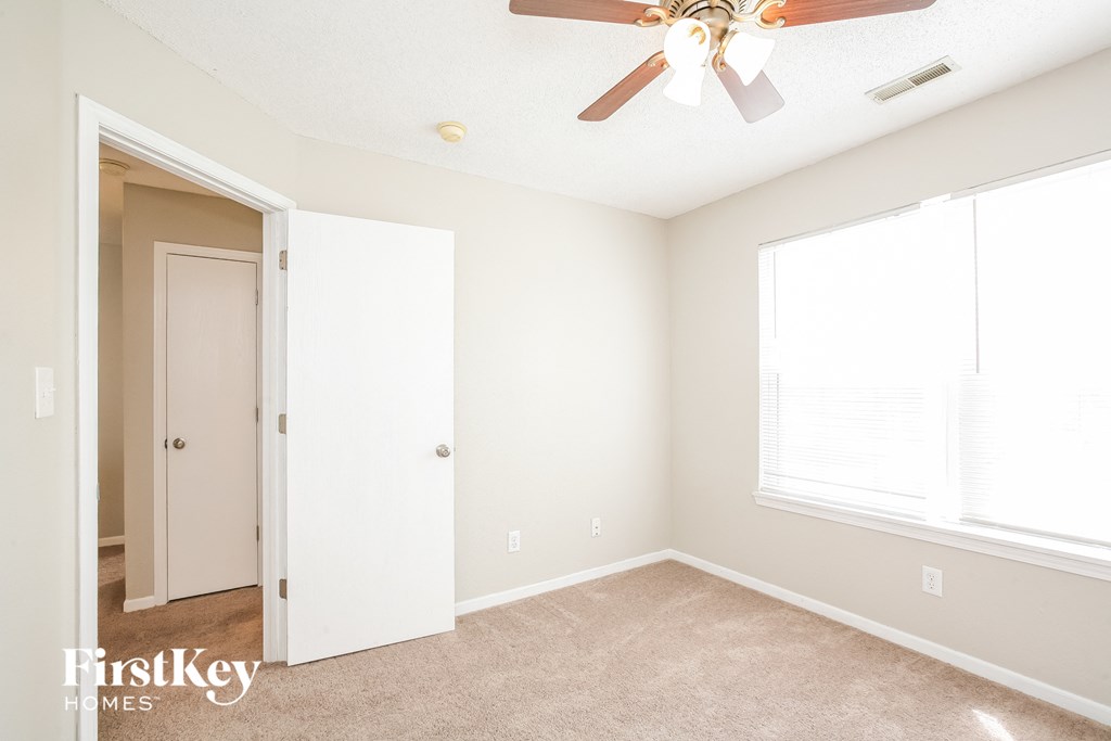 a bedroom with a ceiling fan and a closet
