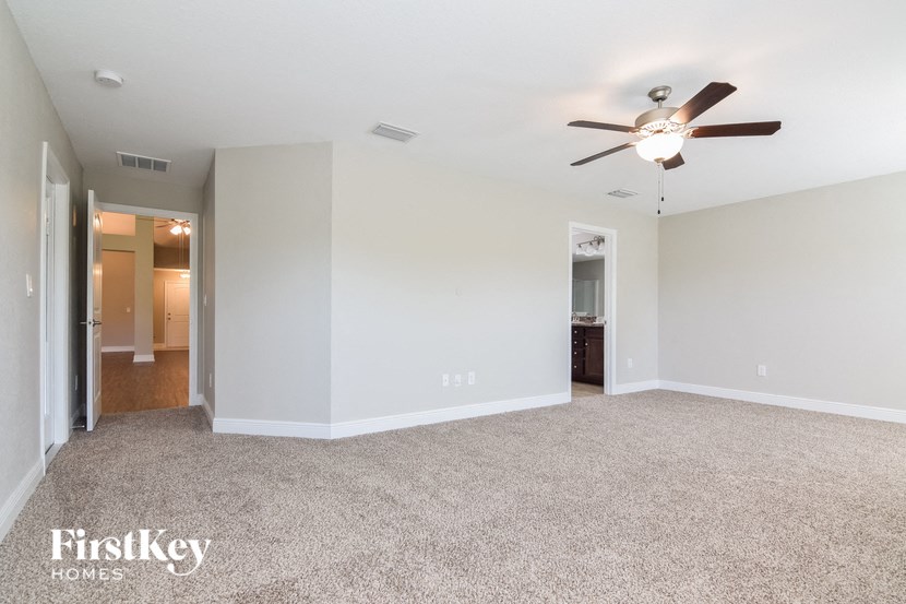 an empty living room with a ceiling fan