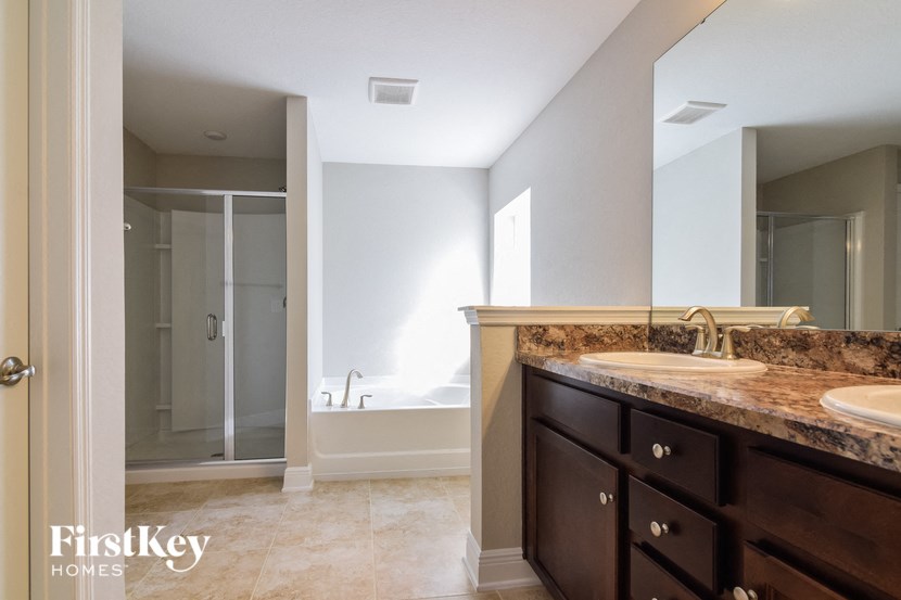 a bathroom with a shower and a sink and a mirror