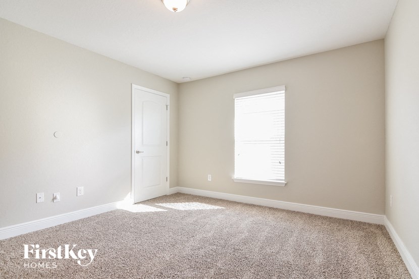 a room with carpet and a door and a window