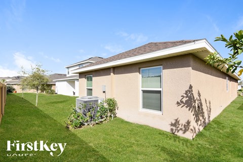 a beige house with a yard and grass