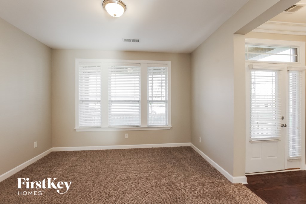 a bedroom with a carpeted floor and a white door and window