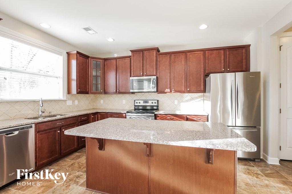 a kitchen with wood cabinets and granite counter tops and stainless steel appliances