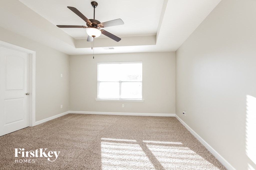 an empty room with a ceiling fan and a window