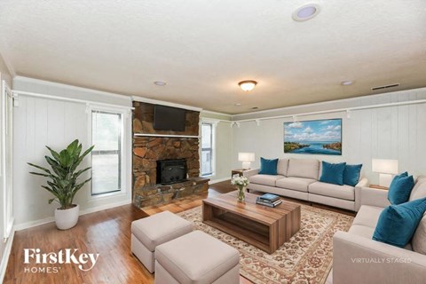 A living room with a fireplace and a painting on the wall.