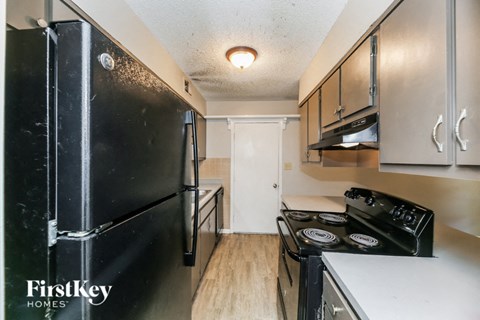 a kitchen with black appliances and a stove and refrigerator