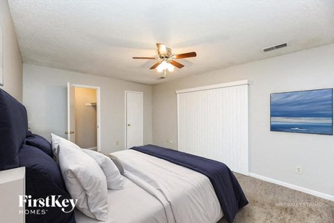 A bedroom with two beds and a ceiling fan.