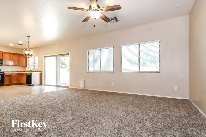 A spacious room with a ceiling fan and a carpeted floor.