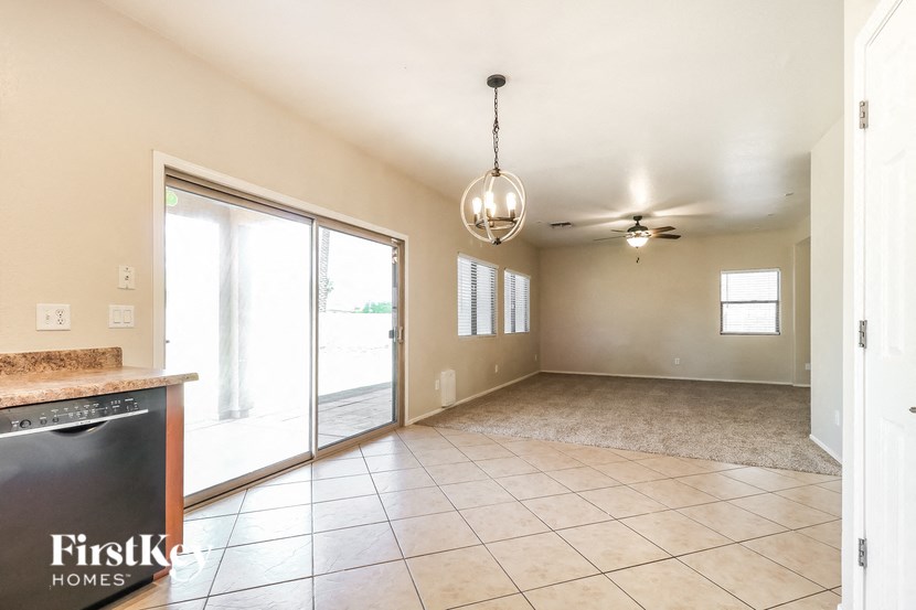 A spacious room with a tile floor and a ceiling fan.