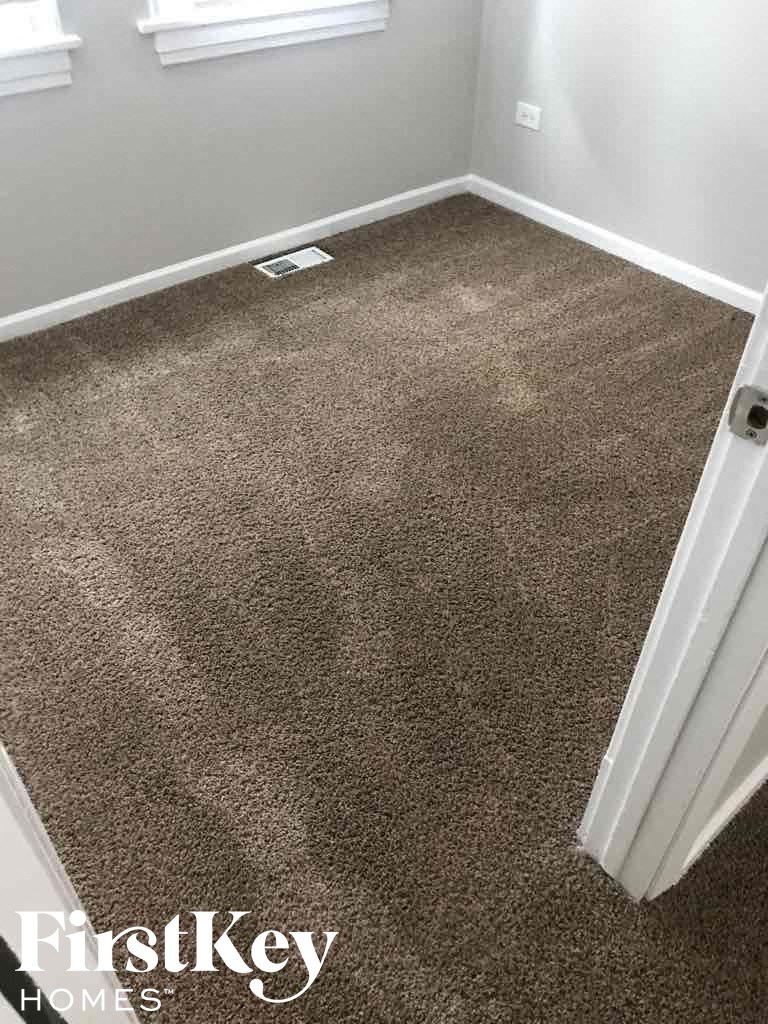 a brown carpeted floor in a room with a white door