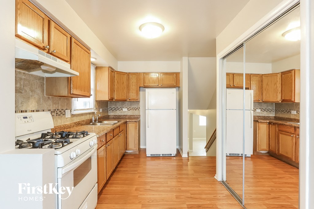 a kitchen with wooden cabinets and white appliances and a refrigerator