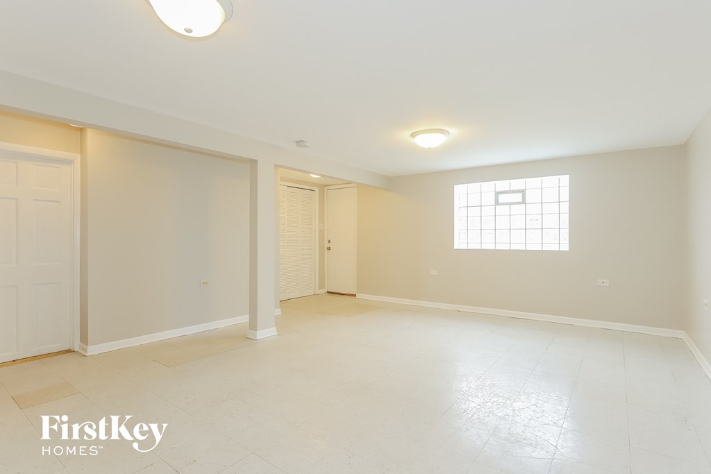 a spacious living room with white tile flooring and a window