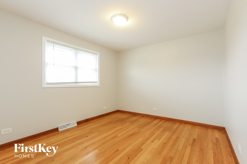 the living room of a house with wood floors and a window