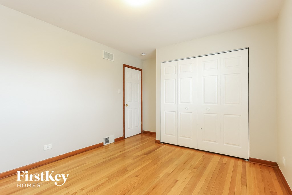 a bedroom with two closets and a wood floor