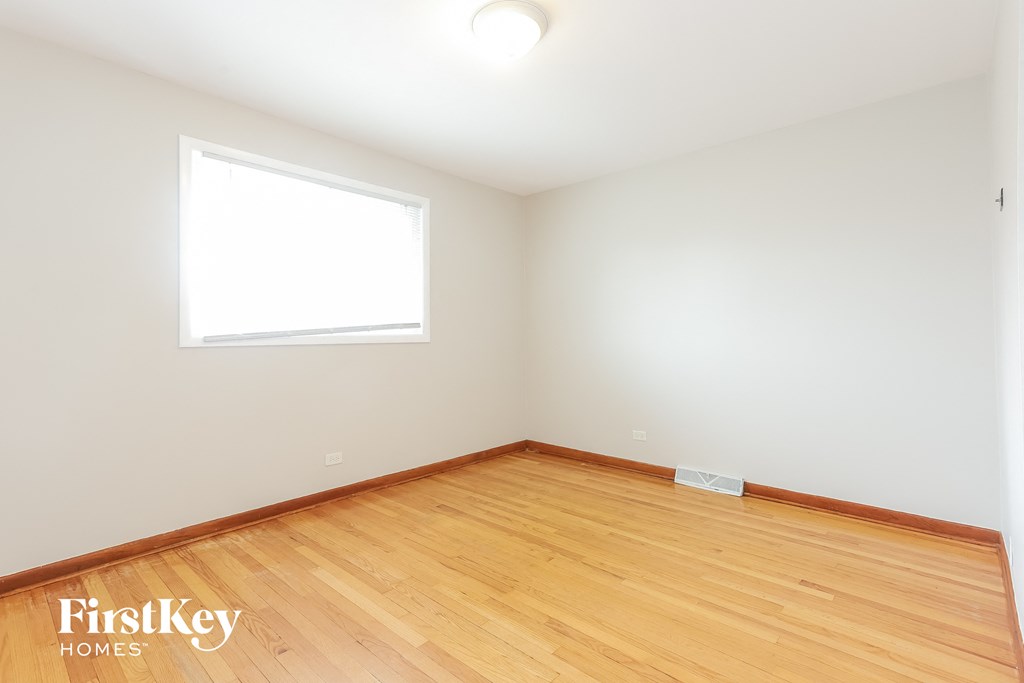 the living room of a house with wood floors and a window