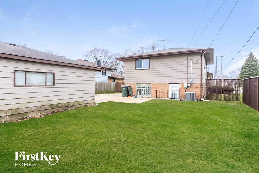 a backyard with a house and a green lawn