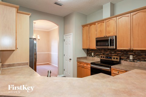 A kitchen with wooden cabinets and a black stove top oven.
