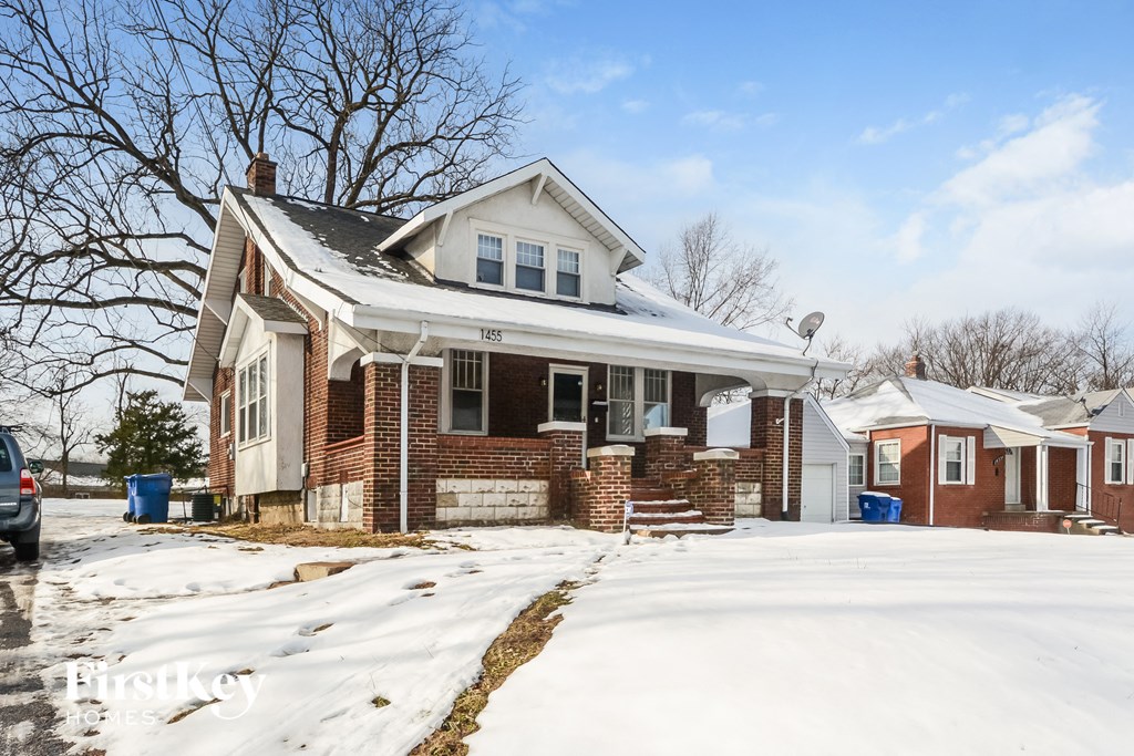 A house with a snow-covered front yard.