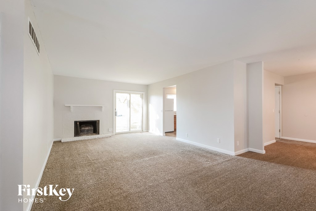 a living room with a carpeted floor and a fireplace
