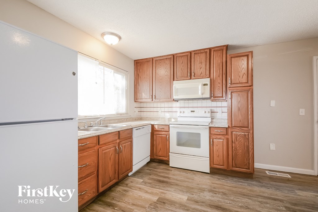 a kitchen with wooden cabinets and white appliances