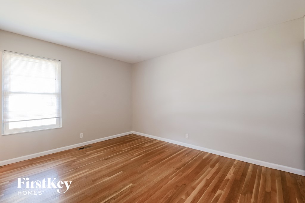 an empty room with wooden floors and a window