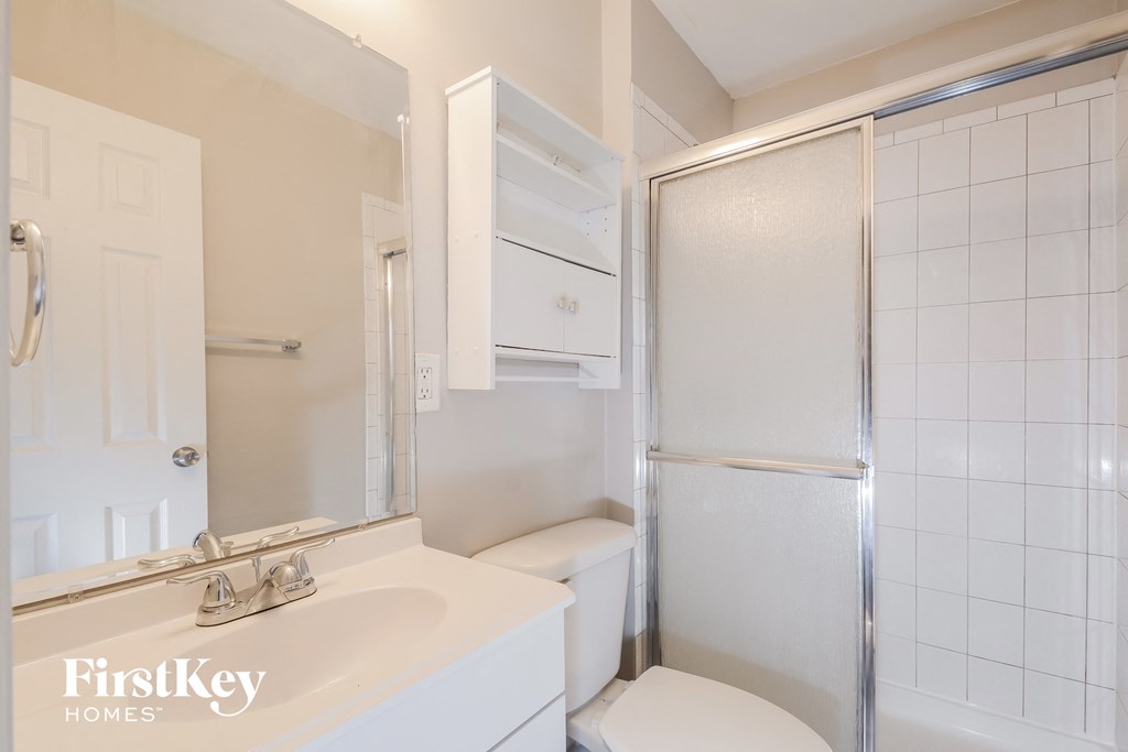 a bathroom with a sink and a shower and a toilet
