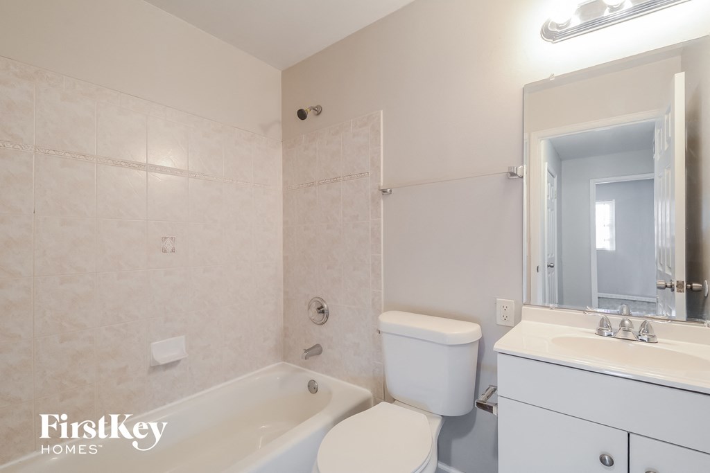 a bathroom with a toilet sink and tub and a mirror