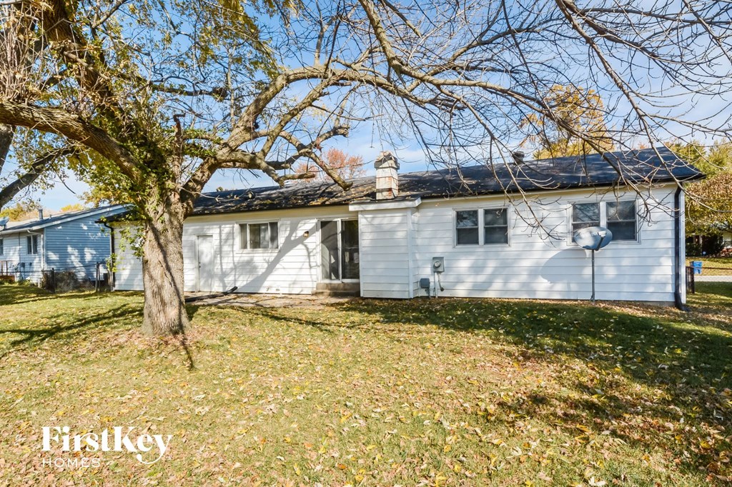 a small white house with a tree in front of it