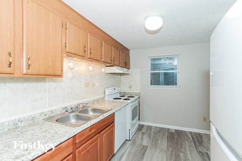 A kitchen with wooden cabinets and a marble countertop.