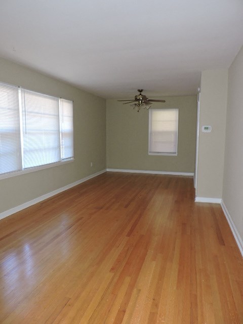 A room with wooden flooring and a ceiling fan.
