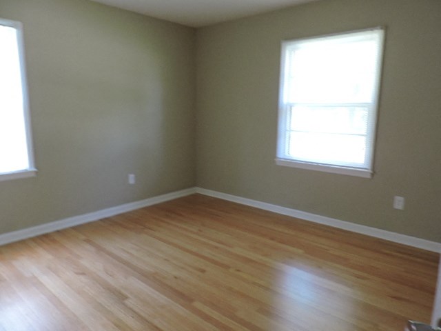 A room with a window and wooden flooring.