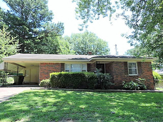 A house with a green lawn in front.