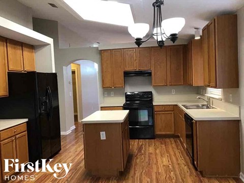 A kitchen with wooden cabinets and black appliances.