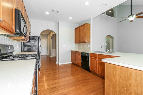 A kitchen with wooden cabinets and a black stove top oven.