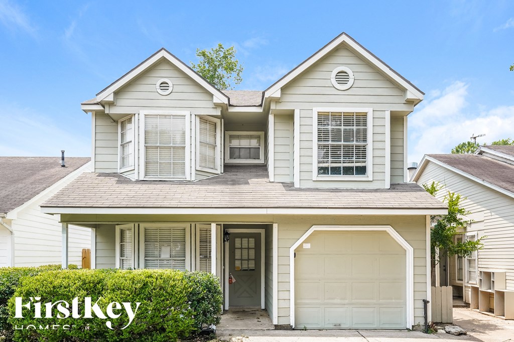 a white house with white shutters and a garage door