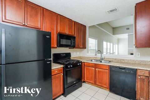 a kitchen with black appliances and wooden cabinets