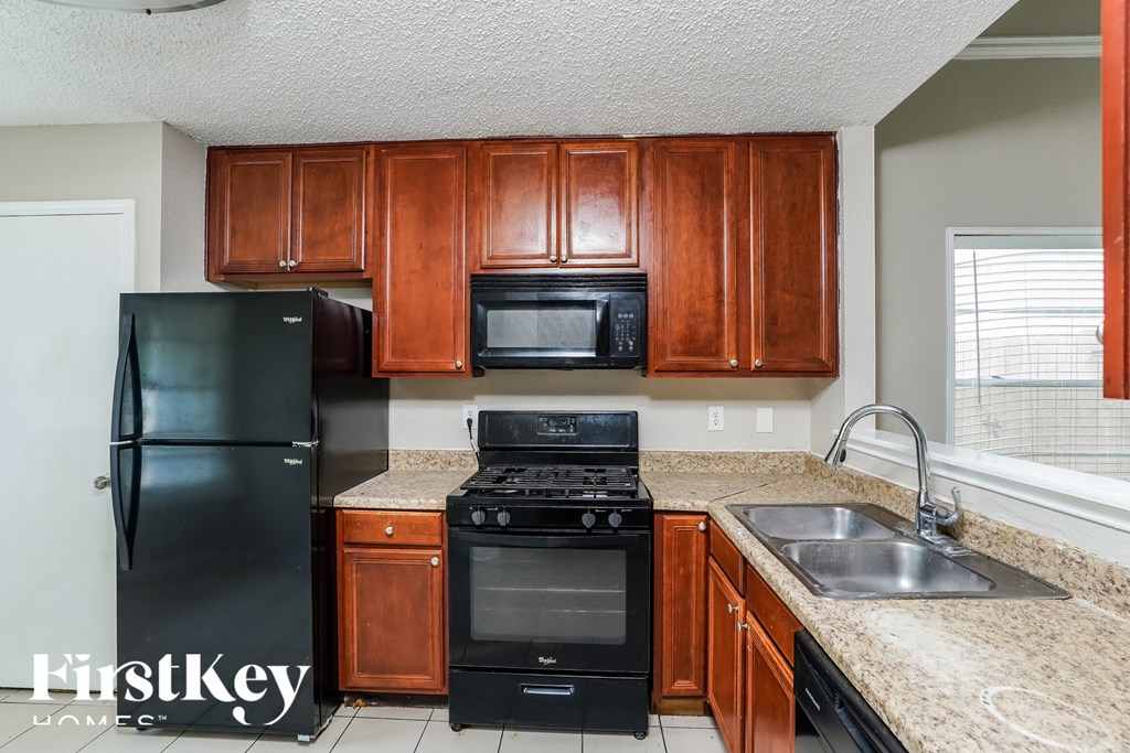 a kitchen with black appliances and granite counter tops